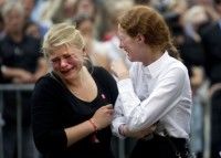 Dos jóvenes lloran durante la misa celebrada este domingo por las víctimas del tiroteo en la isla de Utoeya y la explosión en Oslo, el viernes, en unos ataques cuyo balance sube a 93 muertos y 96 heridos. Foto AFP