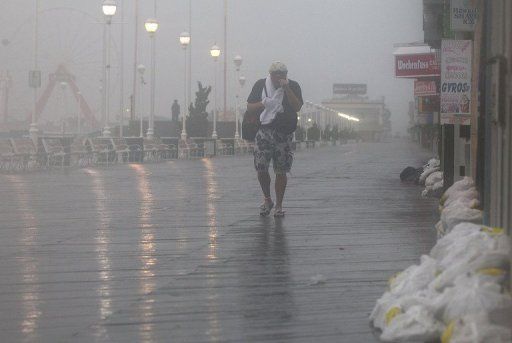 Un hombre camina en medio del viento y la lluvia este sábado en la localidad estadounidense de Ocean City, en Maryland, que ha declarado el estado de emergencia por la cercanía del huracán Irene. Foto: AFP