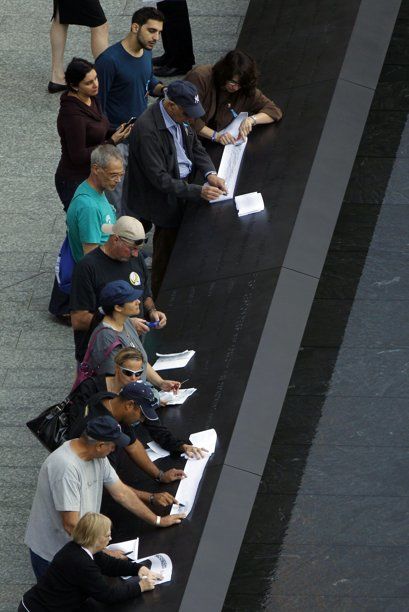 Visitantes usan trozos de papel y pedazos de carbón para copiar los nombres de las víctimas de los atentados terroristas del 11 de septiembre del 2001, en una plaza creada en los sitios exactos donde alguna vez se alzaron las Torres Gemelas del Centro de Comercio Mundial. Foto: AP/Matt Rourke