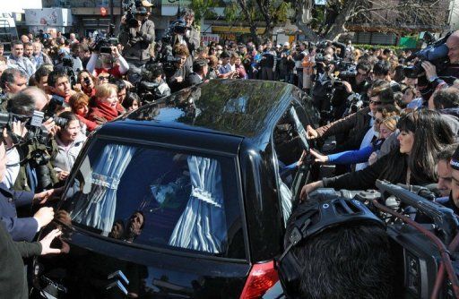 El coche fúnebre con los restos de la pequeña Candela Rodríguez es rodeado por familiares, amigos y vecinos, el 1 de septiembre de 2011 en Buenos Aires. La niña, de 11 años, fue hallada muerta el 31 de agosto tras su secuestro diez días antes. Foto: AFP