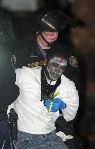 Policías antidisturbios arrestan a uno de varios manifestantes en un parque en Portland, Oregón, a primeras horas del domingo 30 de octubre de 2011. Varios manifestantes, como el de la foto, se habían decorado la cara como si fuera noche de Halloween. Foto: AP foto/Don Ryan