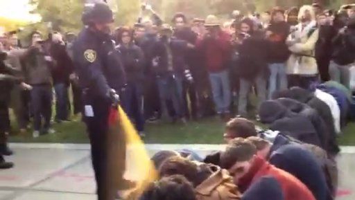En esta imagen tomada de un video, un agente policial rocía con gas pimienta a un grupo de manifestantes sentados en la Universidad de California en Davis, el viernes 18 de noviembre del 2011. Foto: AP/Thomas K. Fowler