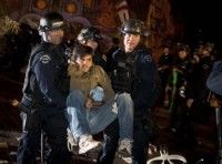 Policías de Los Angeles se llevan a un activista de Ocupemos Los Angeles durante el desalojo de su campamento en el ayuntamiento local, en California. Foto: AP/Bret Hartman
