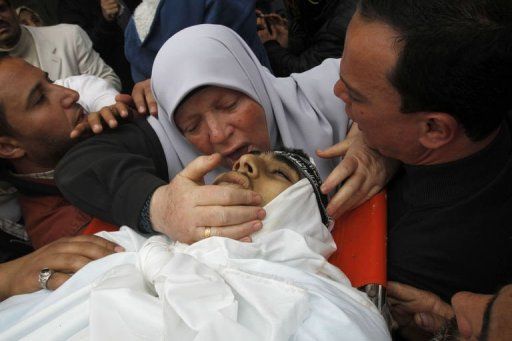 La madre de un palestino muerto en los ataques israelíes le besa en su funeral, este domingo en Gaza. Foto: AFP