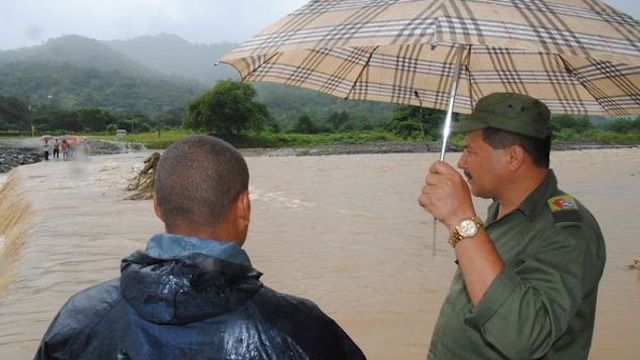 Andrés Alvarez (D), miembro del Consejo de Defensa Municipal valora la crecida del rí­o Yao que cortó el paso a comunidades de la Sierra Maestra, debido a las lluvias asociadas a la tormenta tropical Isaac, en el municipio de Buey Arriba, Granma, el 26 de agosto de 2012. AIN FOTO/Armando Ernesto CONTRERAS TAMAYO