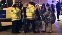 Servicios de emergencia y policías hablan con público del concierto a las afueras del Manchester Arena, tras el atentado (Peter Byrne / AP)